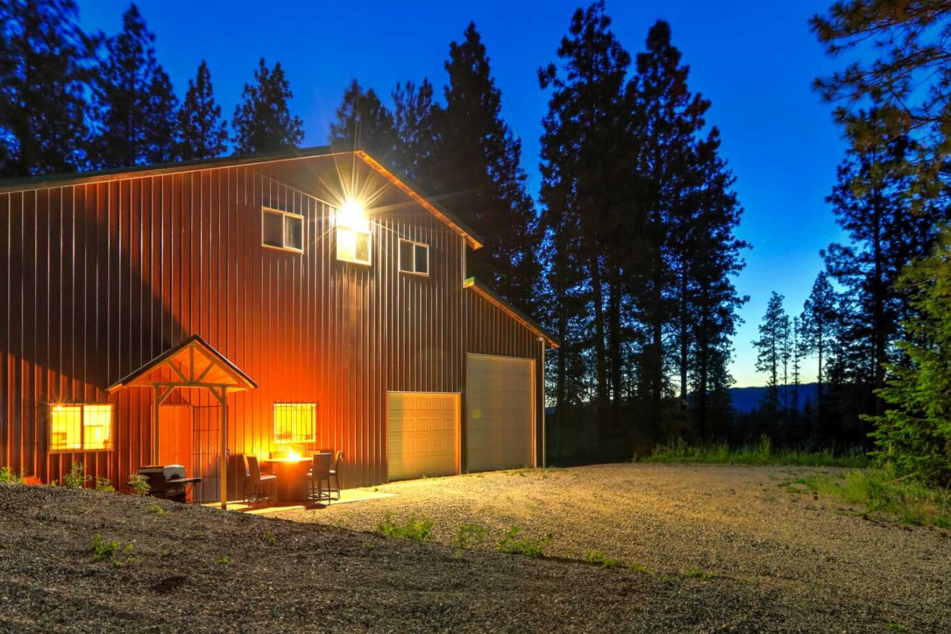 View of a barndominium with a large garage from the outside looking in. 