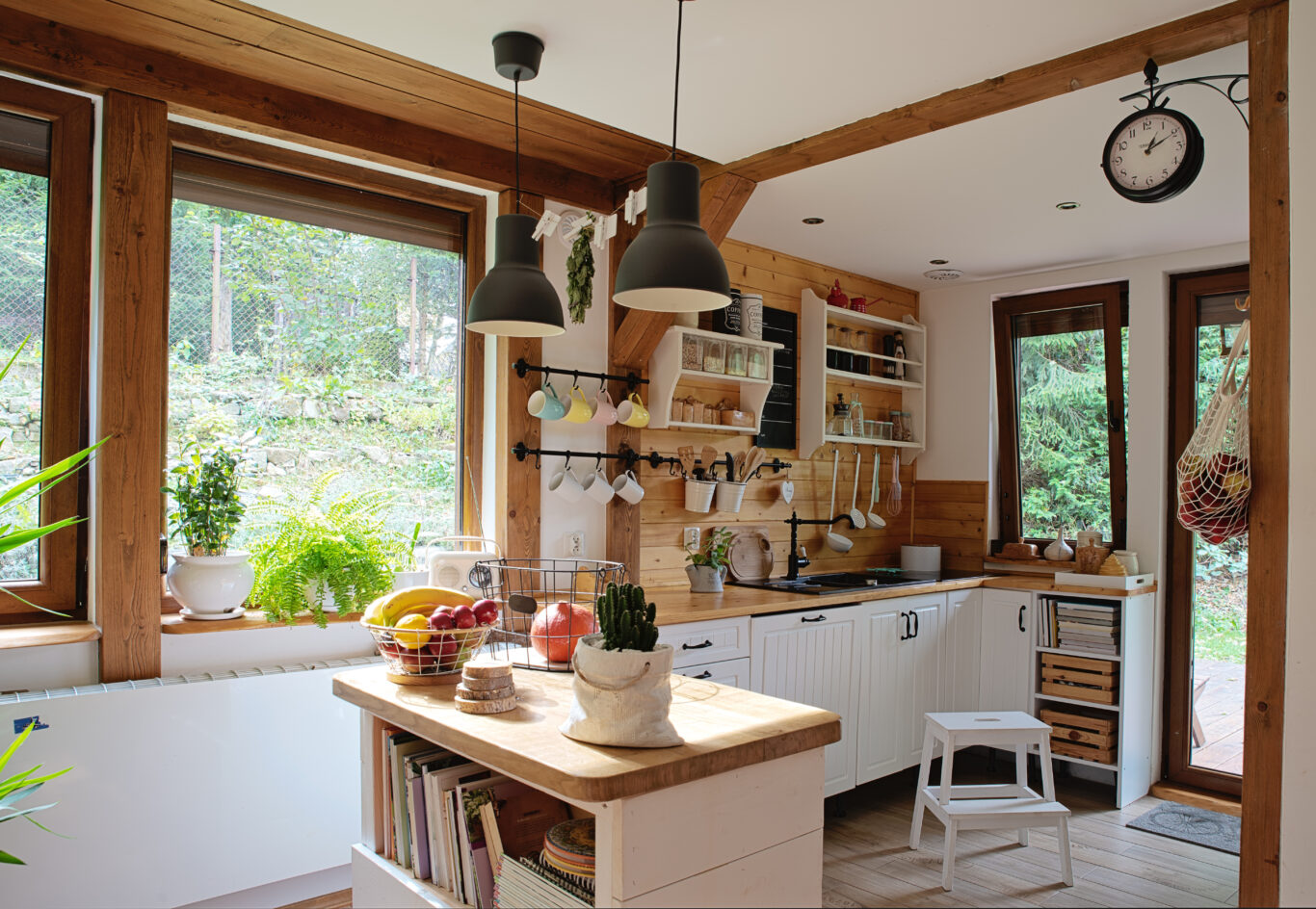 Exposed wood and windows in a simple barndominium kitchen layout.